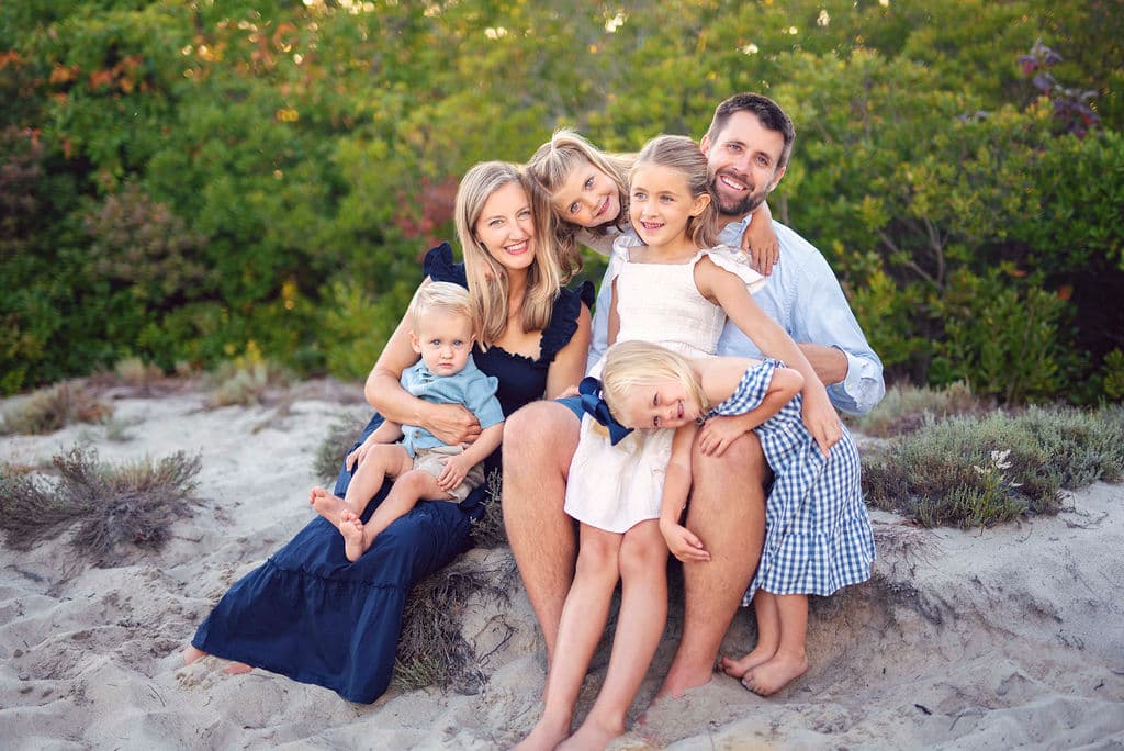 Family of five sitting together in the beach dunes